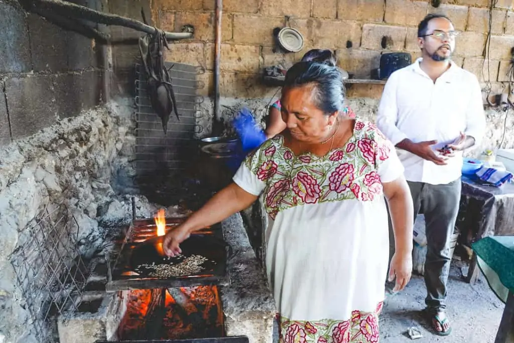 elderly woman cooking meat in Mexico
