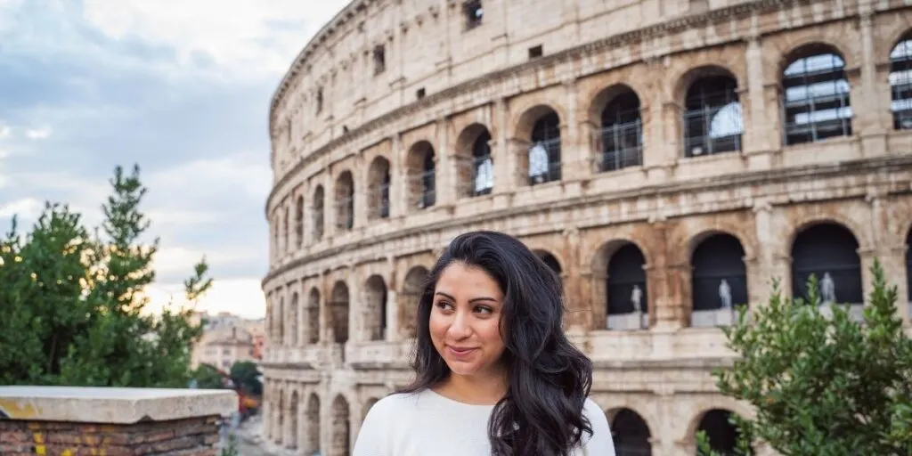 a girl standing in front of the Colosseum 