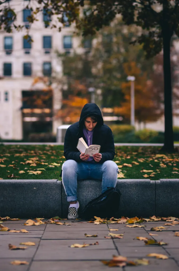 woman sitting while reading a book