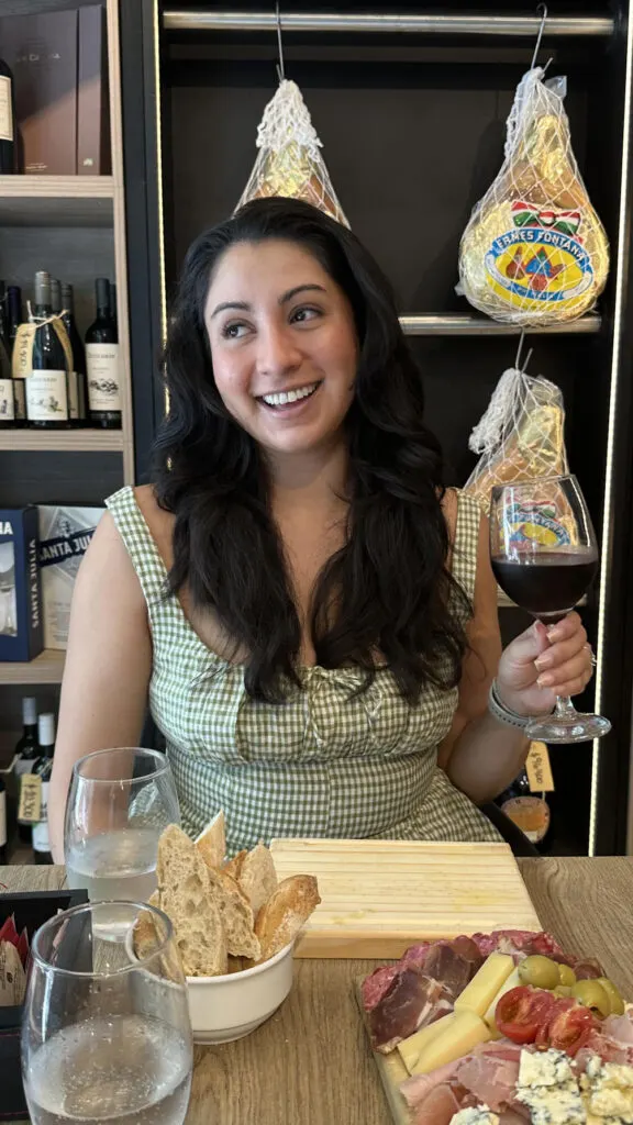 a lady holding a wine glass with wine